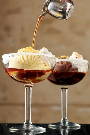 Symposium Cafe Restaurant gourmet dessert selection featuring cakes, waffles, ice cream and specialty sweets.